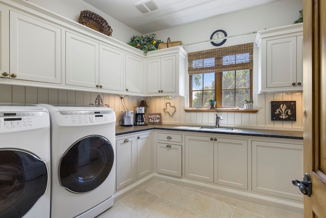 laundry room featuring separate washer and dryer, cabinet space, visible vents, and a sink