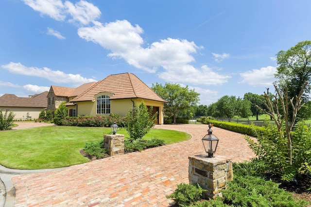 view of patio featuring decorative driveway, a garage, and fence