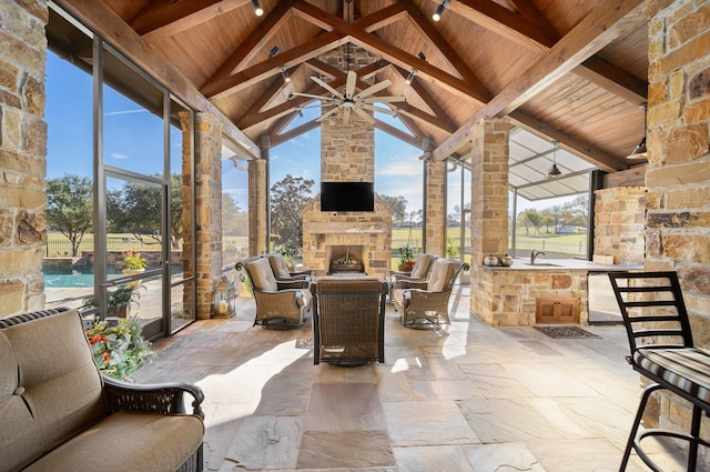 view of patio featuring an outdoor stone fireplace and a ceiling fan