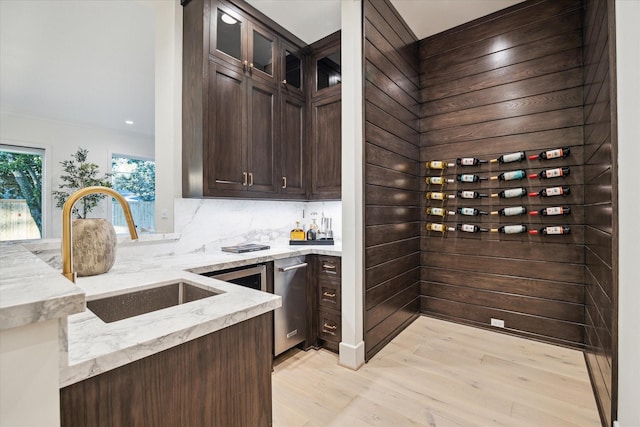 wine cellar featuring bar, light wood finished floors, and a sink