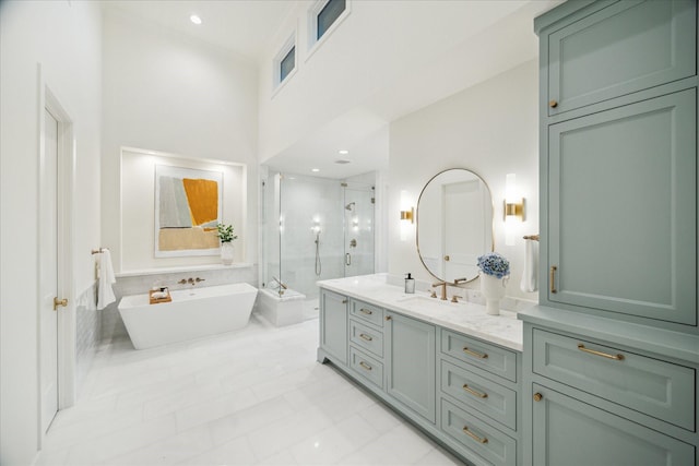 full bathroom with vanity, a shower stall, a freestanding tub, and recessed lighting