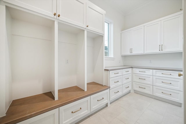 mudroom featuring light tile patterned floors and crown molding