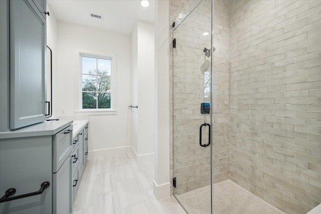 bathroom featuring visible vents, baseboards, vanity, and a shower stall