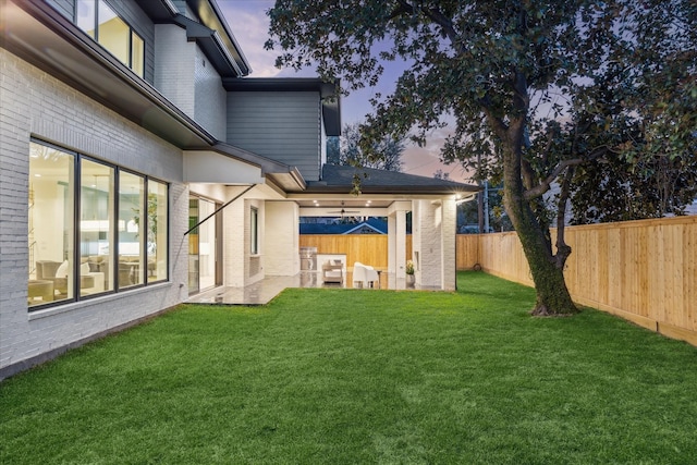 yard at dusk with a fenced backyard