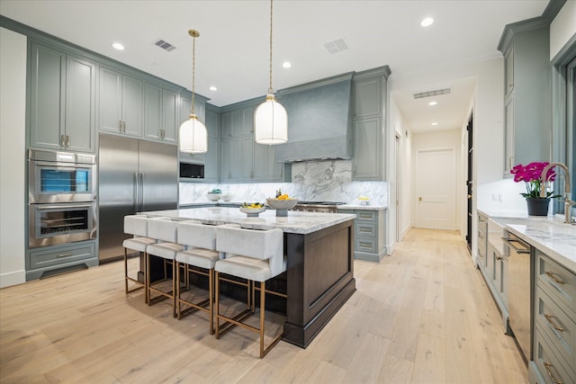 kitchen featuring visible vents, built in appliances, and custom exhaust hood