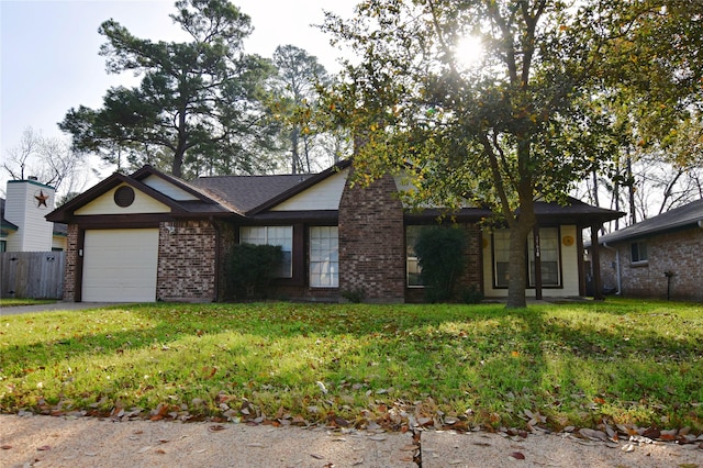 view of front of property featuring fence, driveway, a front lawn, a garage, and brick siding