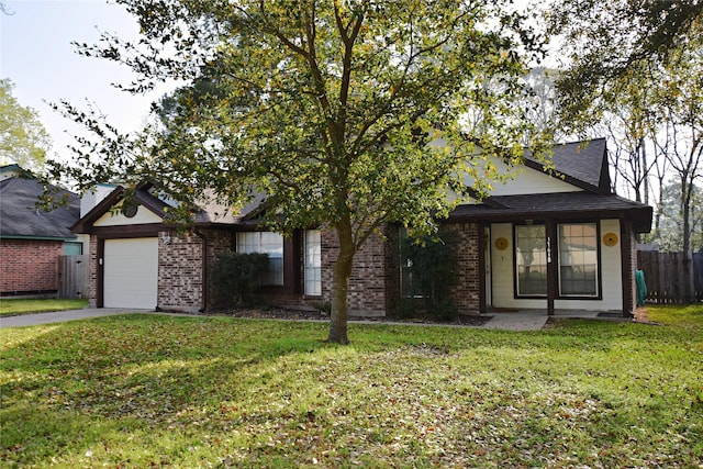 view of front of house with driveway, fence, a front yard, a garage, and brick siding