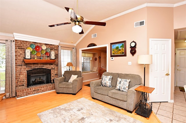 living area featuring visible vents, wood finished floors, a fireplace, and crown molding