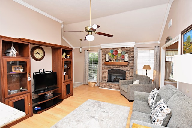 living room featuring vaulted ceiling, a healthy amount of sunlight, a fireplace, and ornamental molding