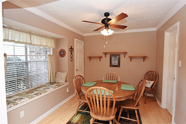 dining area with baseboards, a ceiling fan, wood finished floors, and crown molding