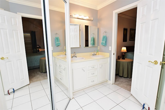 ensuite bathroom featuring a sink, tile patterned flooring, ensuite bathroom, and crown molding