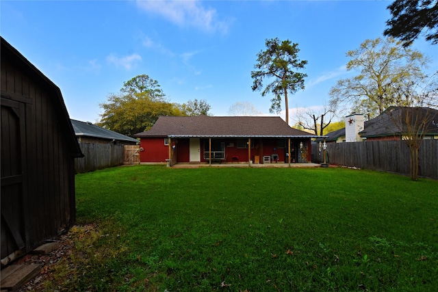 back of house with a lawn and a fenced backyard