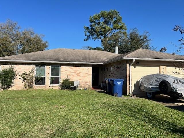 back of house featuring brick siding, a lawn, and a garage