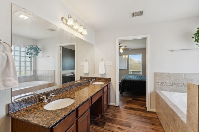 ensuite bathroom featuring a sink, a bath, and ensuite bathroom