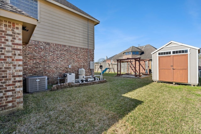 view of yard with an outbuilding, fence, central air condition unit, a storage shed, and a playground