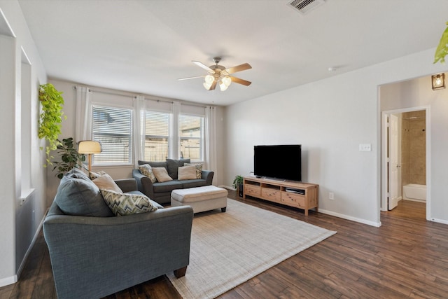 living room featuring dark wood finished floors, baseboards, visible vents, and ceiling fan