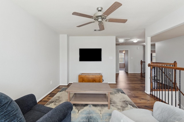 living room with visible vents, attic access, baseboards, and wood finished floors