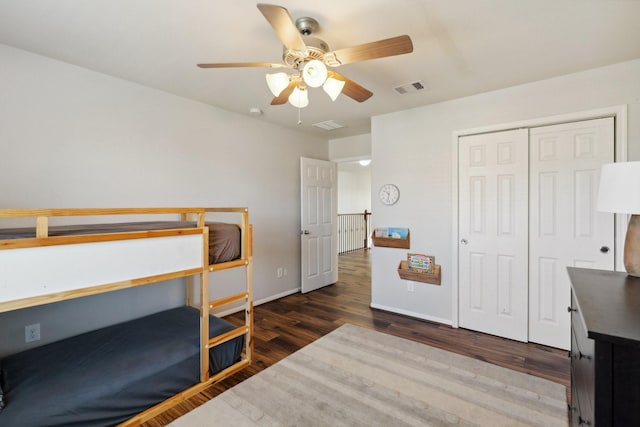 bedroom with visible vents, ceiling fan, baseboards, wood finished floors, and a closet