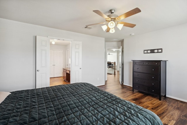 bedroom featuring ceiling fan, wood finished floors, visible vents, and baseboards