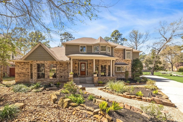 view of front facade featuring brick siding and covered porch