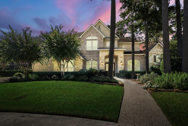 view of front of house featuring a yard and stone siding