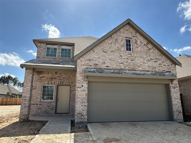 view of front of property with brick siding, driveway, and a garage