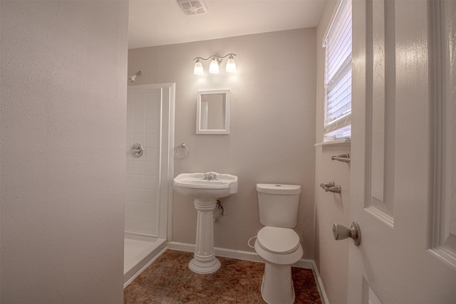 full bath featuring tile patterned floors, visible vents, toilet, a tile shower, and baseboards