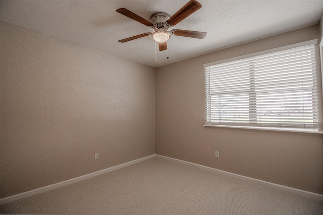 carpeted empty room featuring a ceiling fan, a healthy amount of sunlight, and baseboards