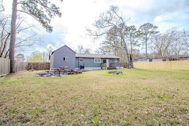 rear view of house with a fenced backyard and a lawn