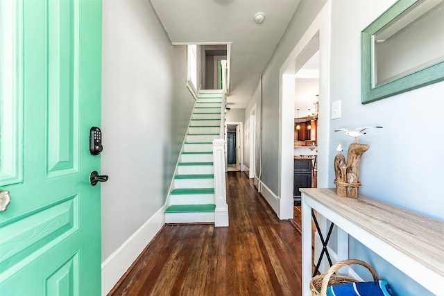 foyer entrance featuring stairs, dark wood-style floors, and baseboards