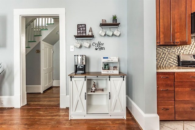 bar featuring tasteful backsplash, stairs, baseboards, and wood finished floors