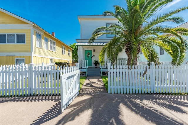 view of front of house featuring a fenced front yard, a porch, and a gate