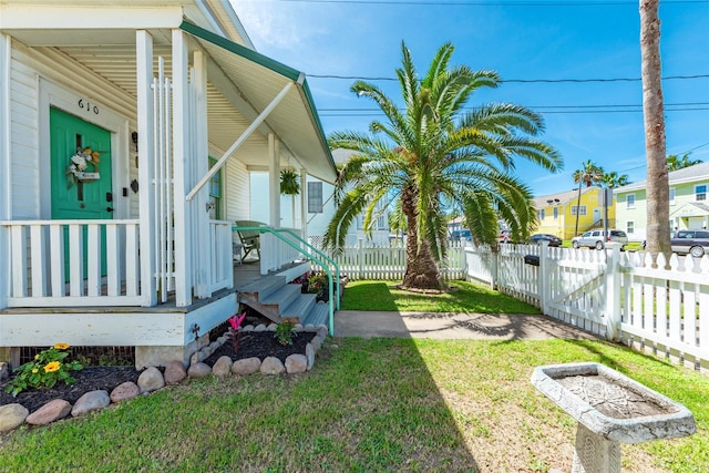 view of yard with a residential view, covered porch, and fence