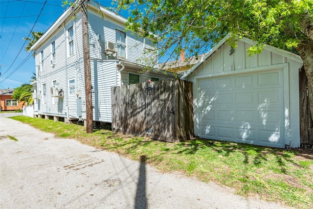 view of property exterior with an outbuilding, cooling unit, board and batten siding, and a detached garage