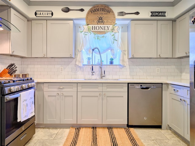 kitchen with a sink, stainless steel appliances, wall chimney range hood, and light countertops