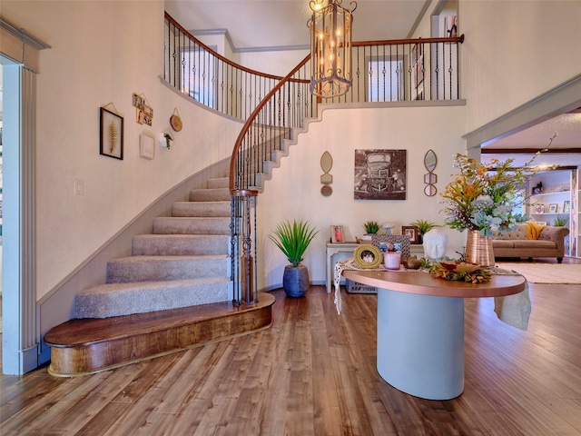 9530 Arcade Dr, Spring, TX 77379 - stairway with an inviting chandelier, a high ceiling, and wood finished floors