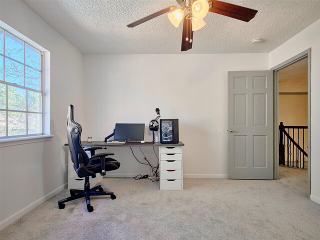 carpeted home office featuring baseboards and a textured ceiling