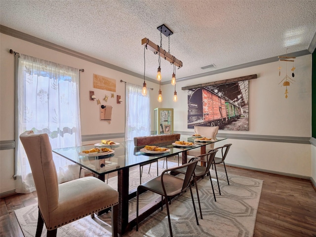 dining space featuring a healthy amount of sunlight, wood finished floors, and ornamental molding