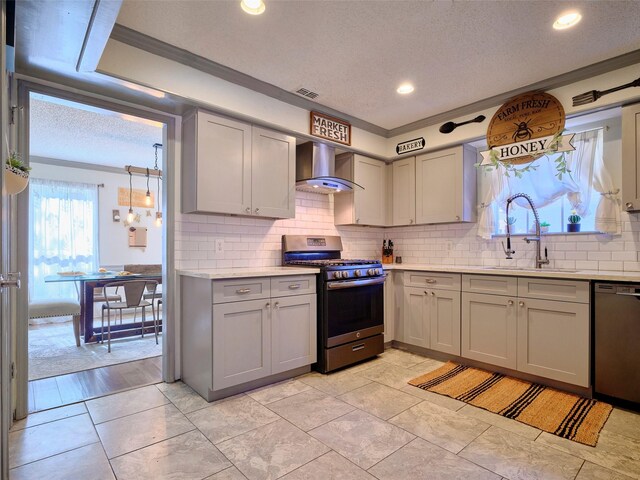 kitchen with stainless steel gas range, gray cabinets, a sink, black dishwasher, and wall chimney exhaust hood