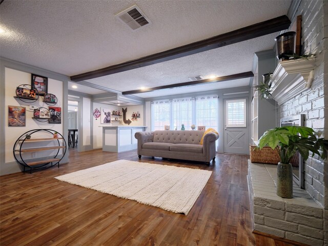 living area with visible vents, wood-type flooring, and a textured ceiling