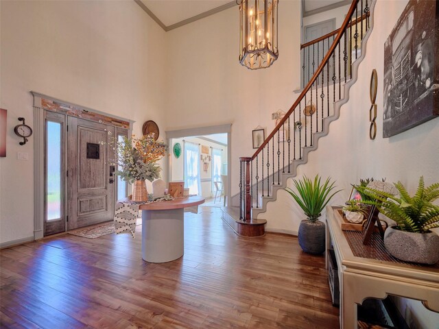 foyer entrance featuring stairs, wood finished floors, baseboards, and ornamental molding