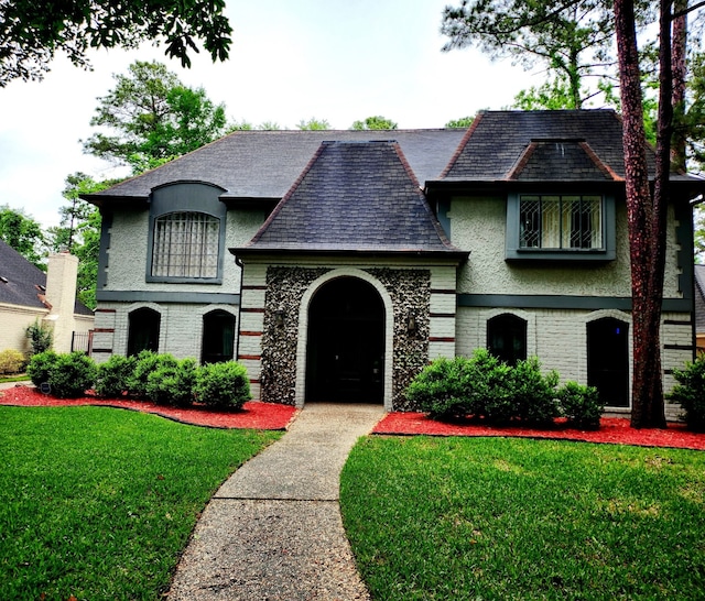 9530 Arcade Dr, Spring, TX 77379 - french country style house featuring brick siding, stucco siding, and a front lawn