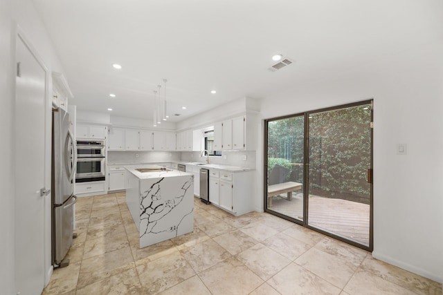 kitchen with visible vents, light countertops, appliances with stainless steel finishes, white cabinetry, and a sink