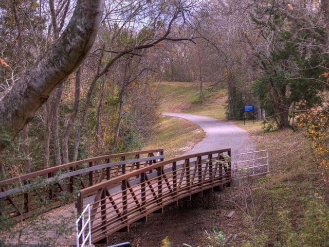 view of property's community featuring a deck and a forest view