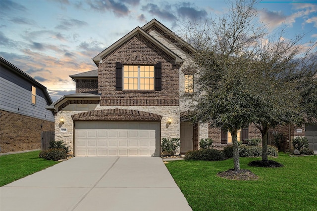 french country home with a lawn, driveway, stone siding, a shingled roof, and brick siding