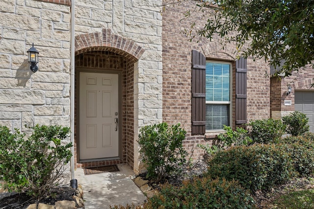 property entrance with stone siding and brick siding