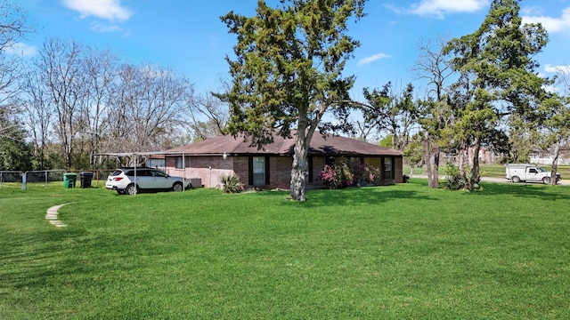 view of front of home with brick siding, a front lawn, and fence