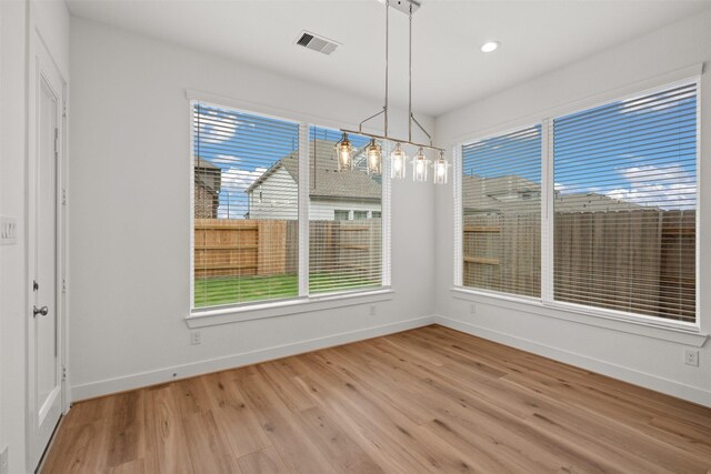 16174 Rustling Woods Rd, Conroe, TX 77302 - unfurnished dining area featuring light wood-style floors, baseboards, healthy amount of natural light, and recessed lighting