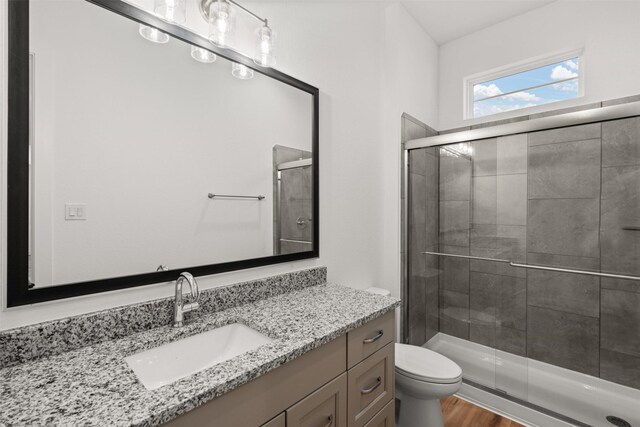 16174 Rustling Woods Rd, Conroe, TX 77302 - full bathroom featuring vanity, a shower stall, toilet, and wood finished floors