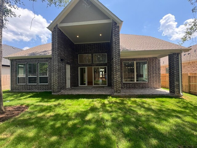 16174 Rustling Woods Rd, Conroe, TX 77302 - rear view of property featuring brick siding, a patio, and a shingled roof